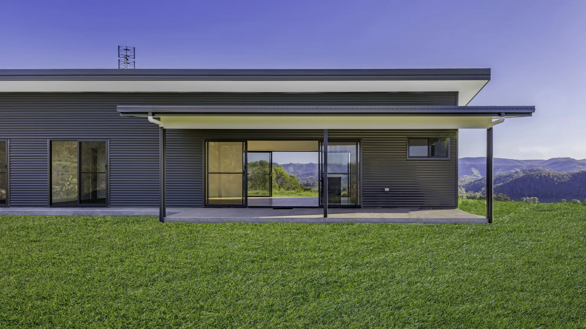 Modern Steel-Framed Kit Home Exterior Modern steel-framed kit home with covered outdoor area in a rural setting